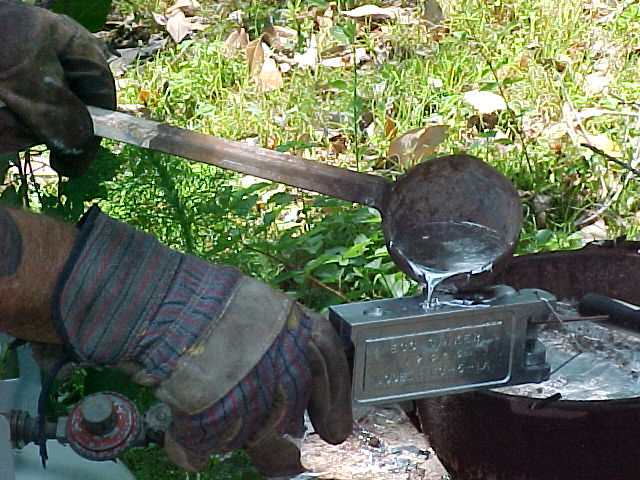 closeup pouring a egg sinker mold with molten lead.jpg